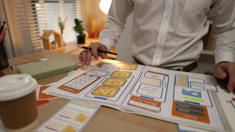 Business professional reviewing mobile application wireframes Stock Footage 343236771