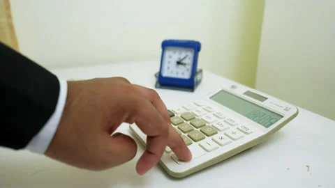 Business Professional Using Calculator at Desk Stock Footage 320725656