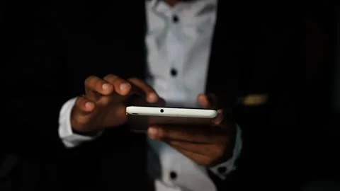 Business professional using smartphone in dark setting Video stock 321936917