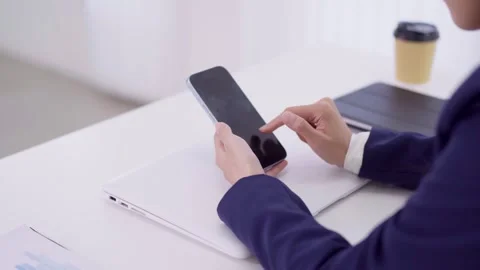 Business professional using smartphone mobile device with laptop computer c.. Stock Footage 334616399