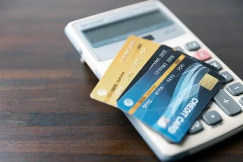 Business professional at work desk using a credit card calculator to manage.. Foto stock