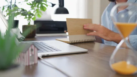 Business professional writing notes at a laptop with a miniature house in t.. Stock Footage 341624845