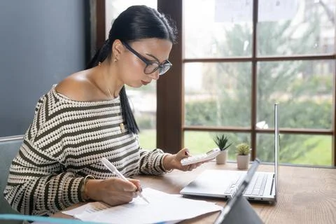 Business Professional Writing Notes While Working on Laptop Stock Photos