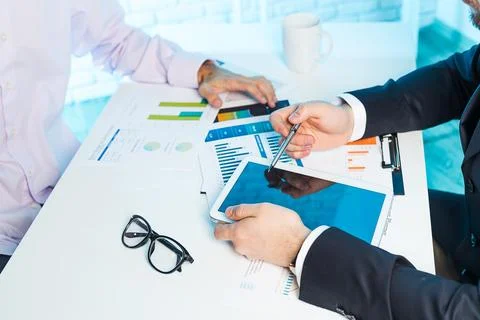 Business professionals analyze data and discuss strategies during a meeting at Stock Photos