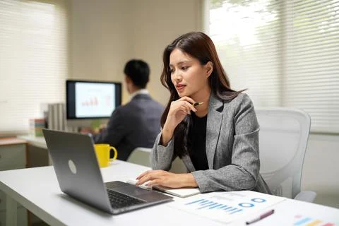 Business professionals analyzing data and working on laptop during office Stock Photos