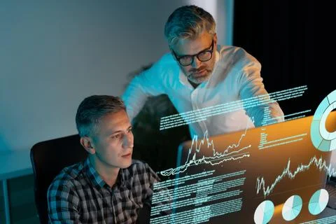 Business Professionals Analyzing Data on Transparent Screen in Modern Office Stock Photos