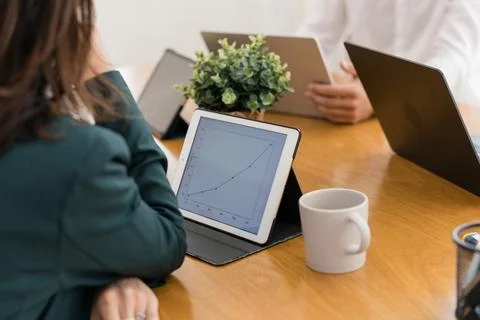 Business professionals analyzing growth statistics on tablet Stock Photos