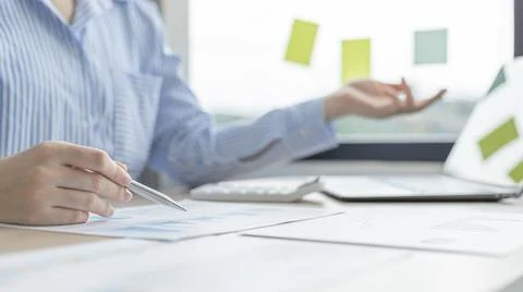 Business professionals are analyzing data using laptops to compute company an Stock Photos