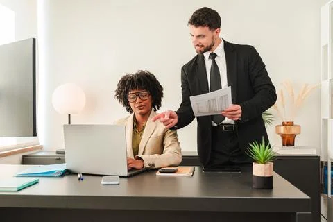 Business professionals collaborating at desk while discussing project details Stock Photos