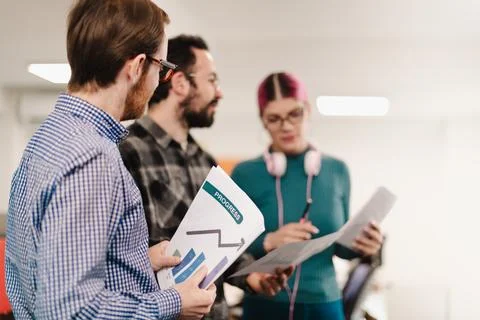 Business professionals discussing progress on project in modern office Stock Photos