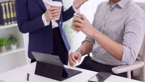Business professionals drinking coffee discussing project collaboration at .. Stock Footage 334995912