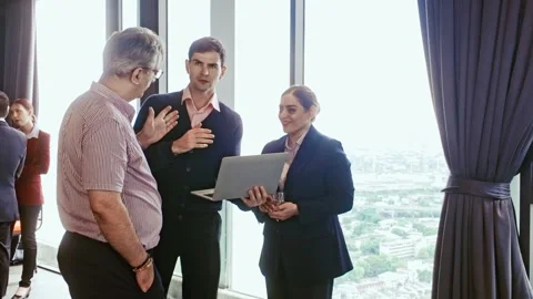 Business professionals engaging in a conversation while reviewing data on laptop Stock-Footage 315016658