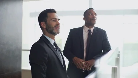 Business professionals looking at office building interior Video stock 75171537
