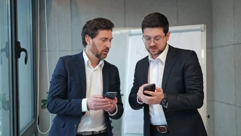 Business Professionals Share Insights Using Smartphones in Office Stock Footage 330155769