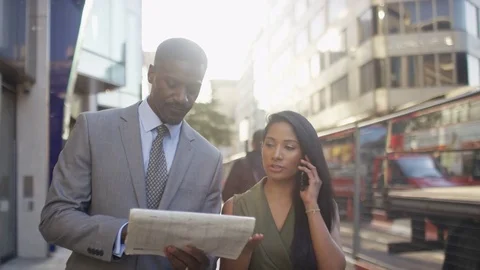 Business professionals walking and checking news in the paper, in slow motion Stock-Footage 83648789