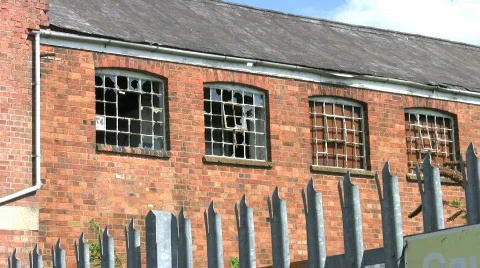 Business recession. Broken windows of a closed and derelict factory building. UK Stock Footage 375323