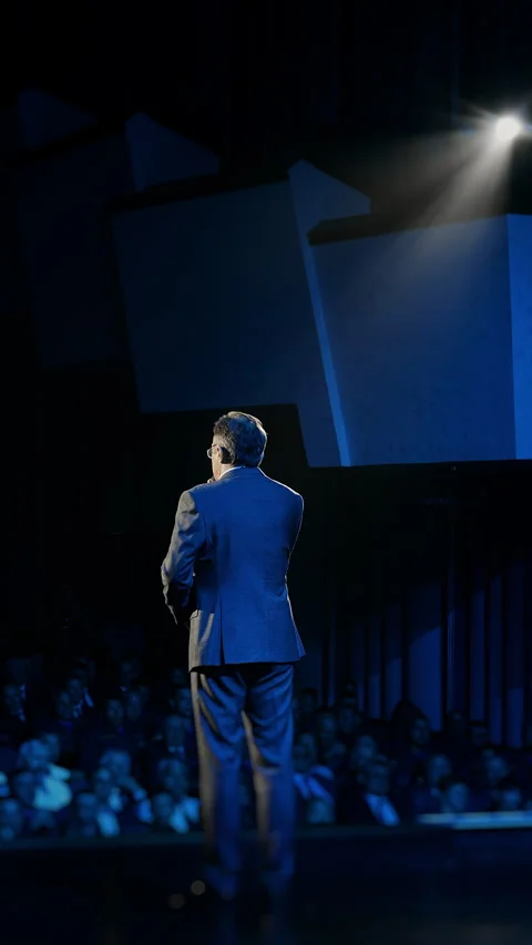 Business Speaker Giving Presentation on Stage in Spotlight Stock Footage 345558078