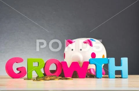 Business success concept, piggy bank, stacking coins and word GROWTH on woode Stock Photos