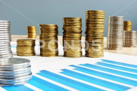 Business success. Profit. Stack of coins and financial chart. Stock Photos