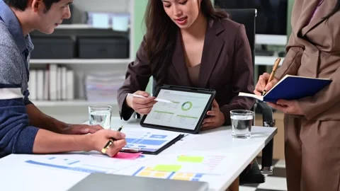 Business team analyzing data and charts in a modern office, collaborating o.. Stock Footage 312443552