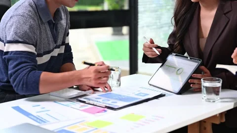 Business team analyzing data and charts in a modern office, collaborating o.. Stock Footage 312443556