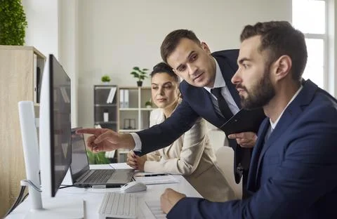 Business team analyzing data on computer in modern office, strategy discussion Stock Photos
