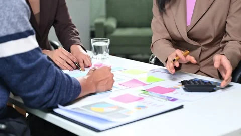 Business team analyzing financial data, charts, and graphs using tablets an.. Video stock 312440589