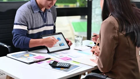 Business team analyzing financial data, charts, and graphs using tablets an.. Stock Footage 312440848