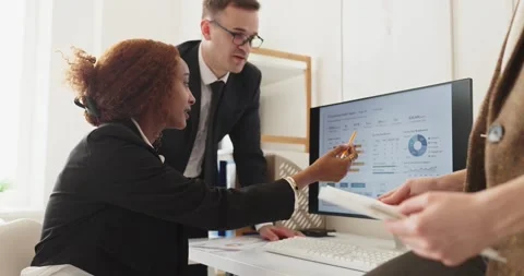Business team analyzing financial data and strategy charts on computer in office Stock Footage 340797191