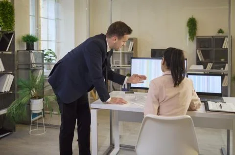 Business team analyzing financial spreadsheets on computer screens in office Stock Photos