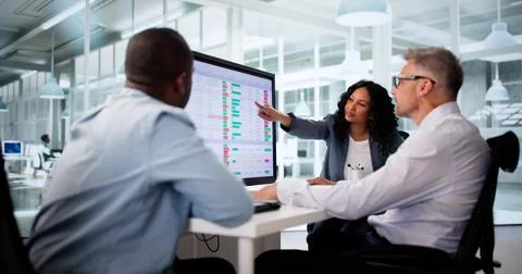 Business Team Analyzing Reports On Multiple Computer Screens In Workplace. Se 스톡 사진