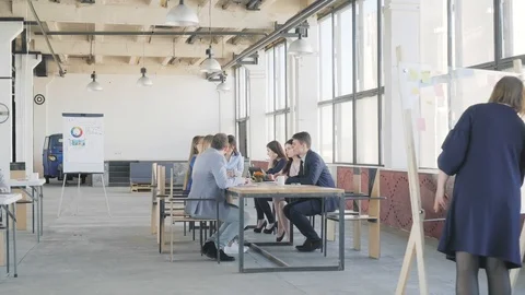 The business team at the big table holds a meeting. Nearby colleagues are Stock Footage 109557699