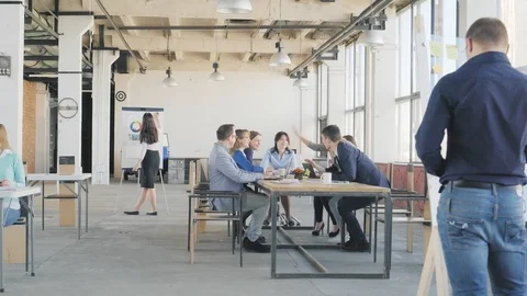 The business team at the big table holds a meeting. Employees get up stretching Stock Footage 109557976