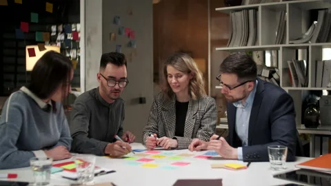 Business Team Brainstorming Using Color Labels On Table In Office. Man Is Видео 130949088