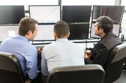 Business team brainstorming while checking data at computer screens. Stock Photos
