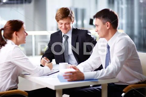 Business team bursting out laughing while holding a discussion Stock Photos