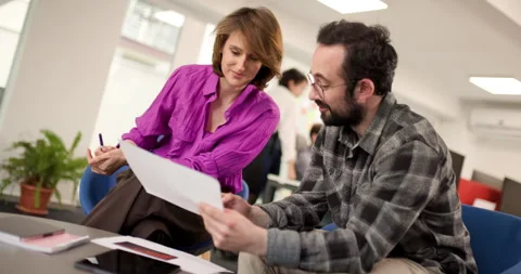 Business team collaborates in office space to discuss project details and plan Stock Footage 338361426