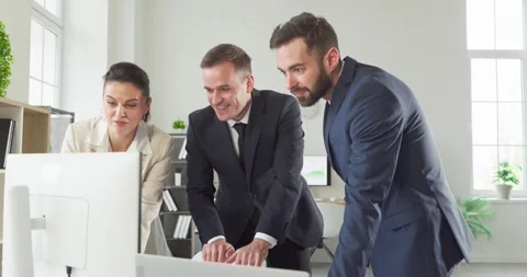 Business team collaborating at computer during planning meeting in modern office Stock Footage 331254867