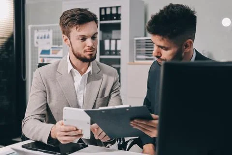 Business team collaborating on digital data analysis in modern office Stock Photos