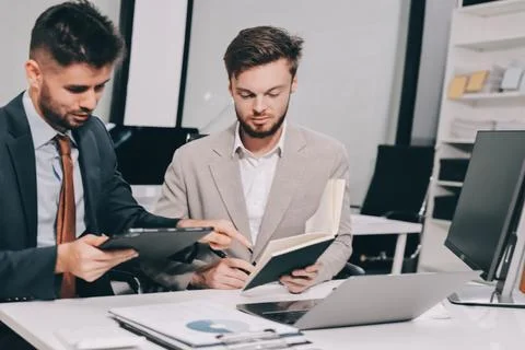 Business team collaborating on digital data analysis in modern office Stock Photos
