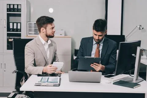 Business team collaborating on digital data analysis in modern office Stock Photos