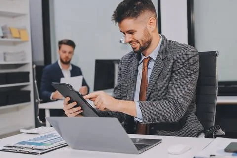 Business team collaborating on digital data analysis in modern office Stock Photos