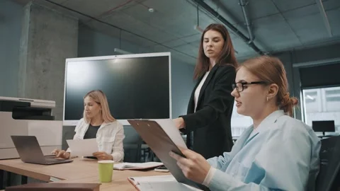Business team discusses documents in modern office setting Stock Footage 318523399
