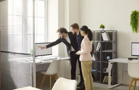 Business team discussing data analysis at monitor in modern office workspace Stock Photos