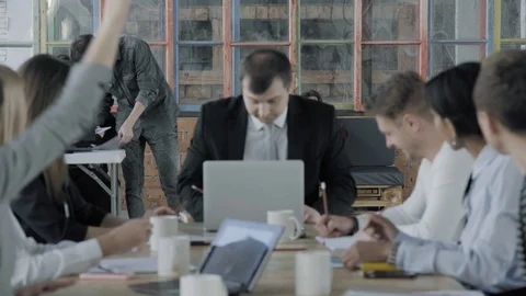 A business team is discussing a project at a large office table. Creative office Stock Footage 124550633