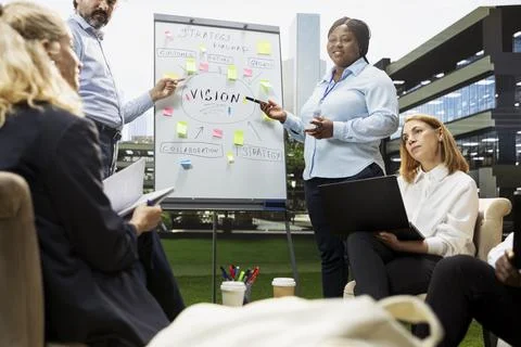 Business team discussing strategy roadmap for whiteboard presentation Stock Photos
