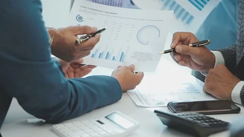 Business team examining data on loan comparison calculator chart Stock Footage 325447166