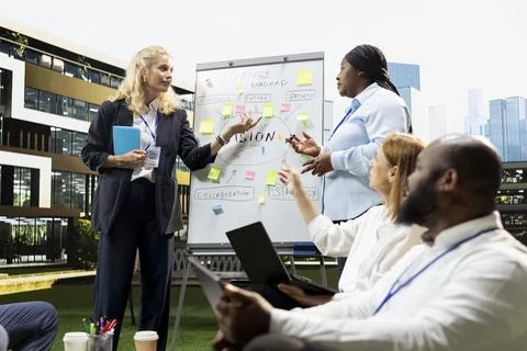 Business team gathering around vision board for outdoor workshop Stock Photos