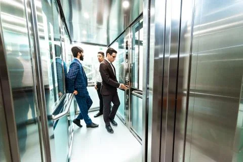 Business team group going on elevator. Business people in a large glass elevator Stock Photos