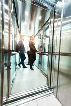 Business team group going on elevator. Business people in a large glass elevator Stock Photos